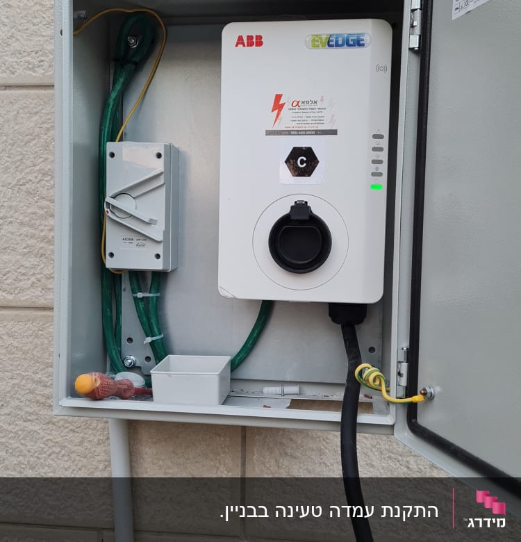 ארון חשמל פתוח עם כבלים ומטען ABB